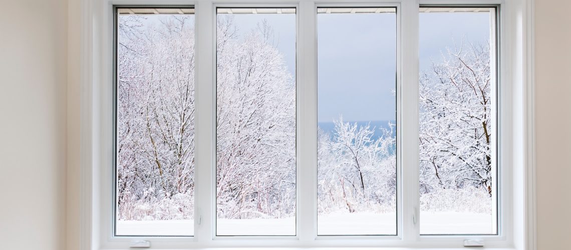 Large four pane window looking on snow covered trees in winter